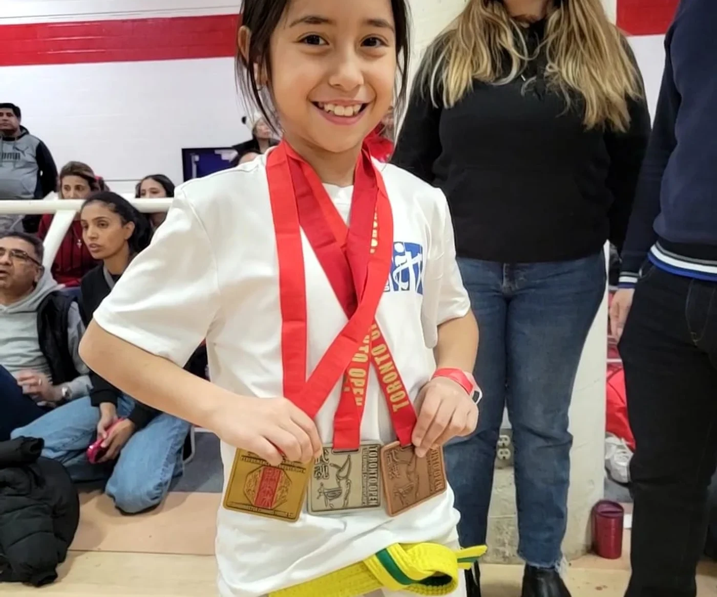 Young M.T.L Taekwondo competitor with tournament medals