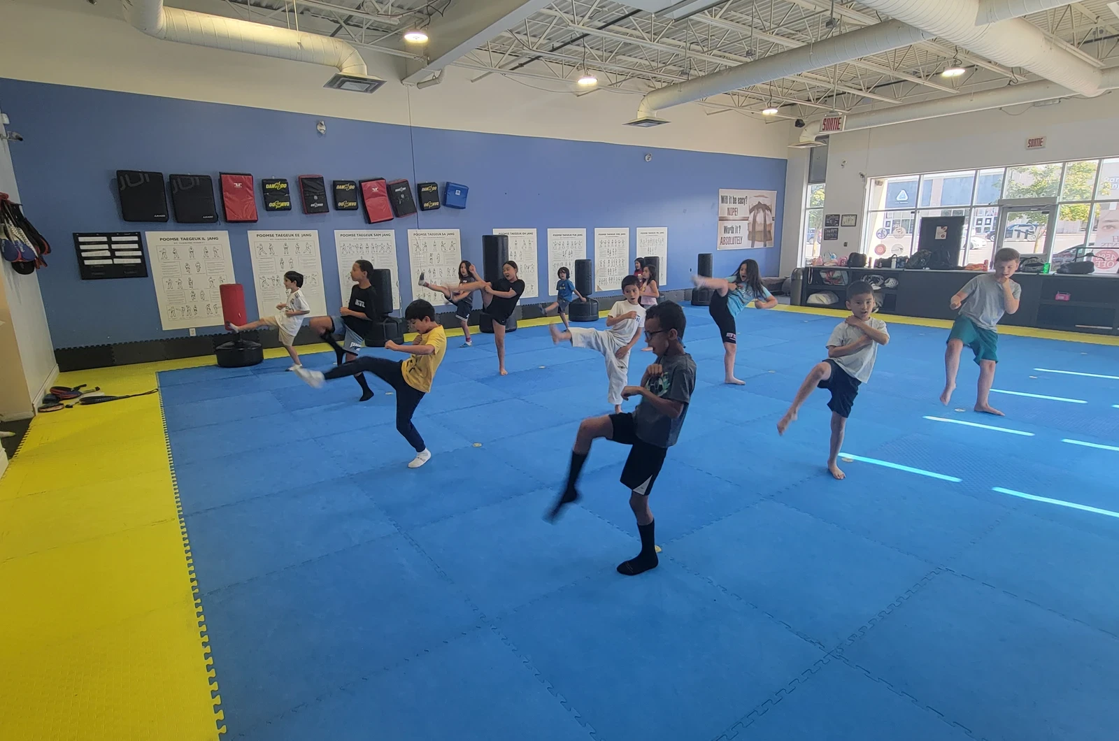 Young students practicing taekwondo kicks at M.T.L Taekwondo summer camp